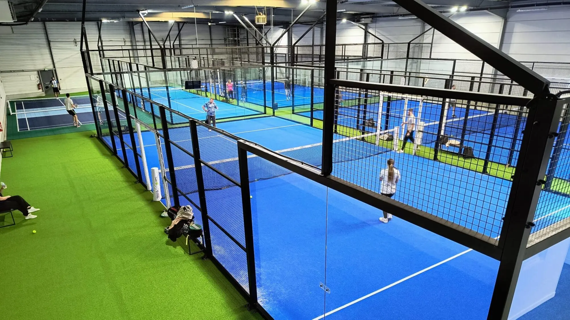 Vista aérea de canchas de pádel iluminadas de noche